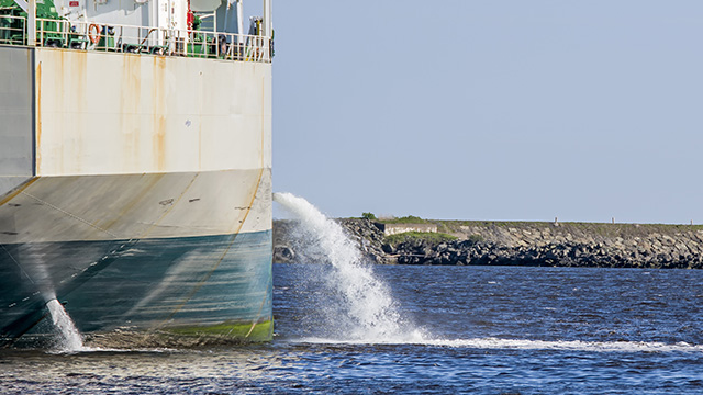 Tanker discharging ballast into the harbor Water flows from the side